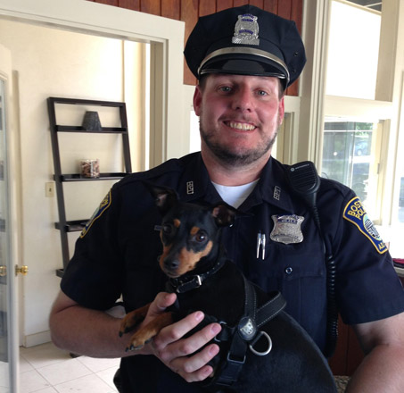 Boston Police officer with small dog in Roslindale