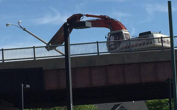 Backhoe rips up a light pole on the Casey Overpass in Forest Hills
