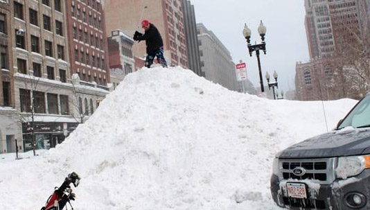 Man hitting golf ball on top of snow mound in Copley Square