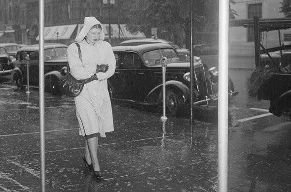 Woman walking on the street in the rain in old Boston