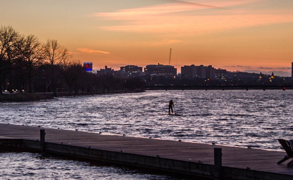 Guy on a paddleboard on the Charles River in winter