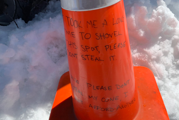 Traffic cone that urges reader not to take parking space or the cone itself in Allston