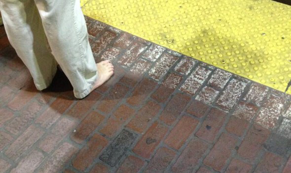 A man with no shoes on the Red Line