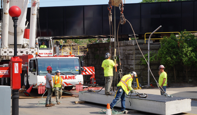 Workers on a piece of the new bridge at Robert Street