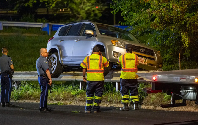 SUV perched on a guard rail on Storrow Drive