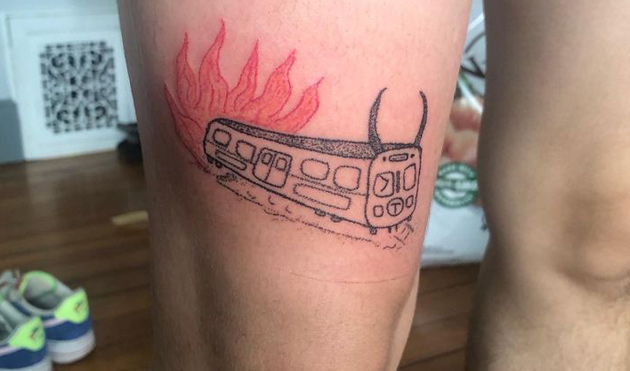 Tattoo showing a devil-horned Orange Line car on fire