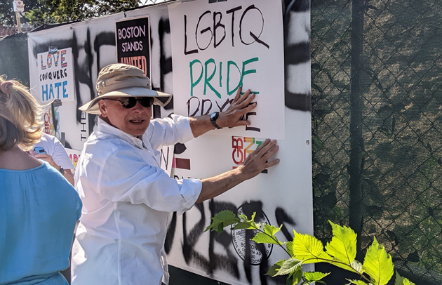 Covering hateful graffiti with pro-Pryde signs