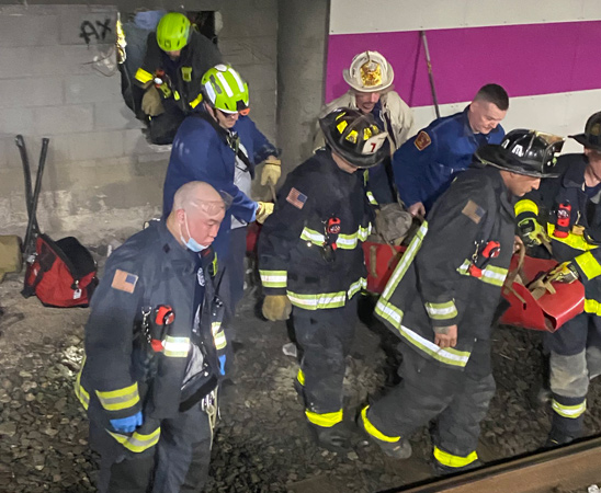 Firefighters rescuing man after breaking open wall at Back Bay