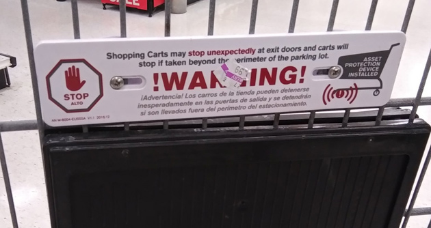 Sign on a shopping carriage that warns the wheels will lock up if taken past the parking lot