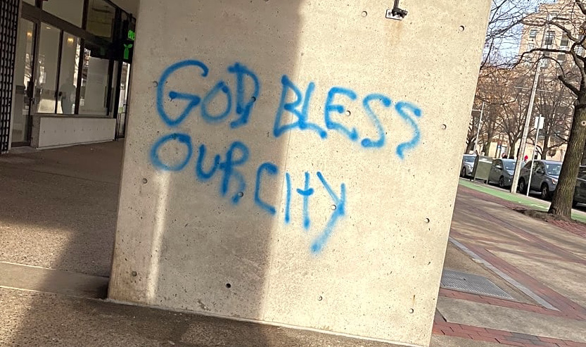 Graffiti on Massachusetts Avenue reading God Bless Our City