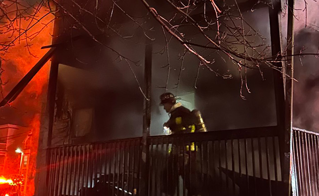 Firefighter on porch at Leston Street fire