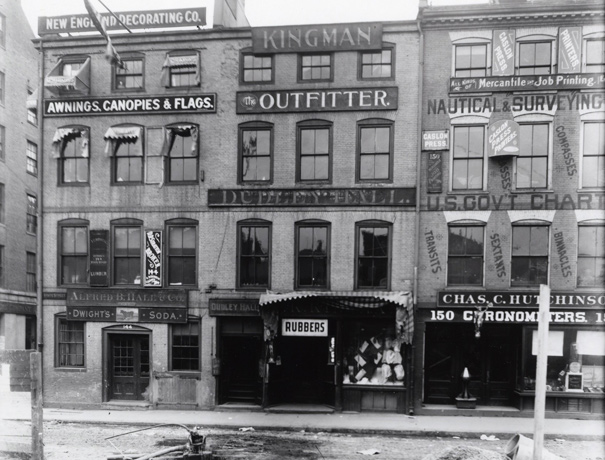 Street scene in old Boston, featuring store selling rubbers