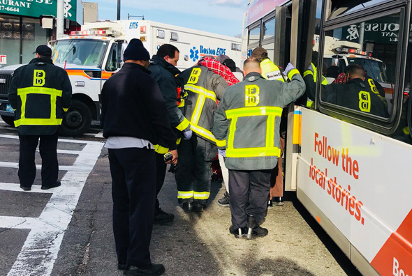 Firefighters help injured person from bus at Hyde Park Avenue and Canterbury Street