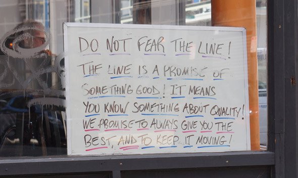 Sign at Figaro's in the Leather District that says to embrace the line