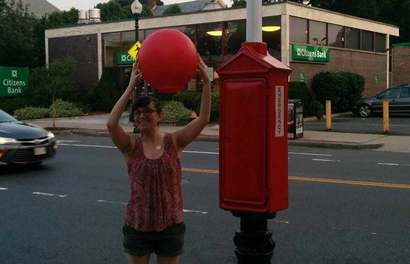 Woman holds giant red ball in Brighton