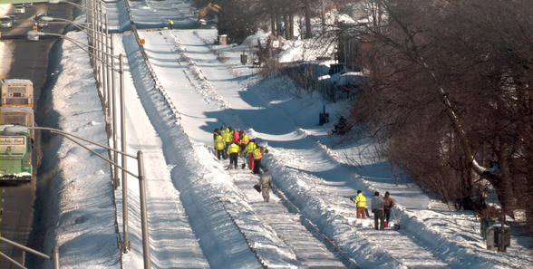Workers clearing ice and snow on the Red Line in Quincy