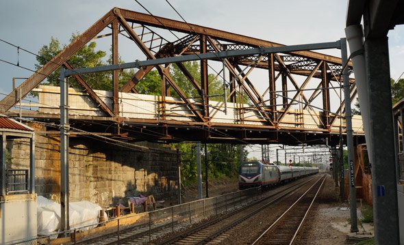 Amtrak train under old bridge in Readville