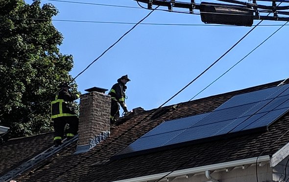 Firefighters on roof in Roslindale