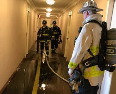 Firefighters in Hawthorne Place hallway