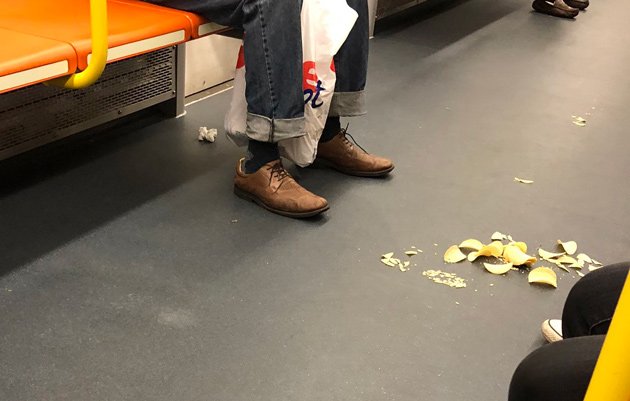 Chips, other trash on the floor of a new Orange Line car