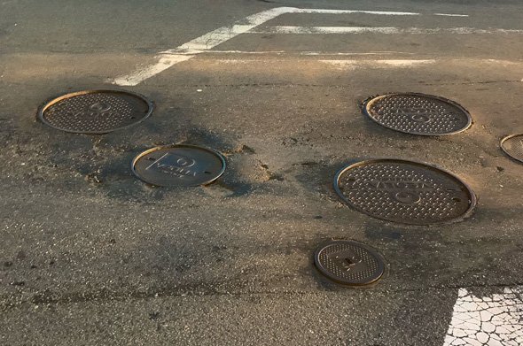 Multiple potholes and Veolia manhole covers