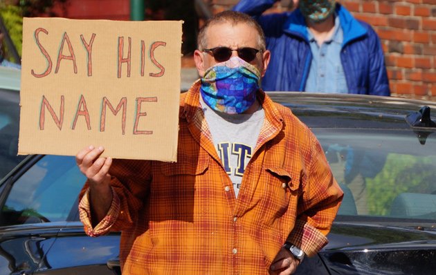 Man with sign: Say his name