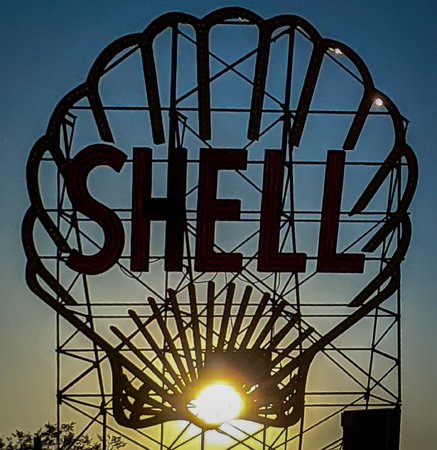Sun coming through the Shell sign on Memorial Drive at sunset