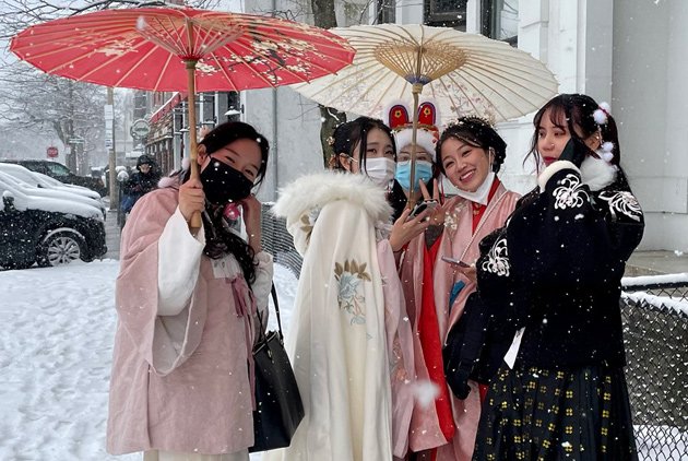 Women with umbrellas in the snow in Allston