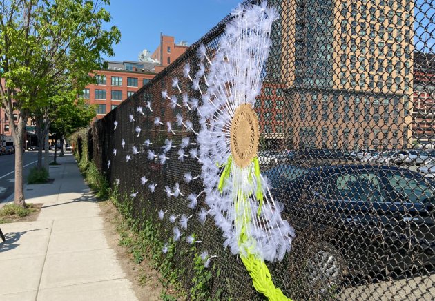 Big knitted dandelion on an A Street fence