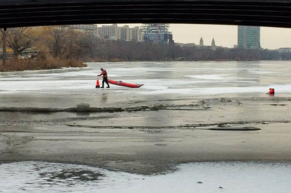 Man picking up cones on the Charles River