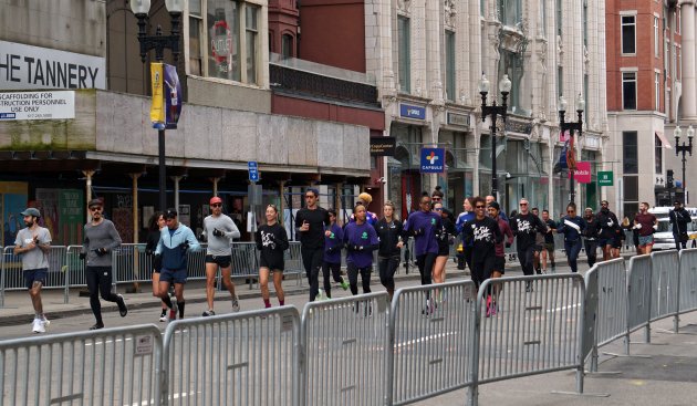 People running down Boylston Street