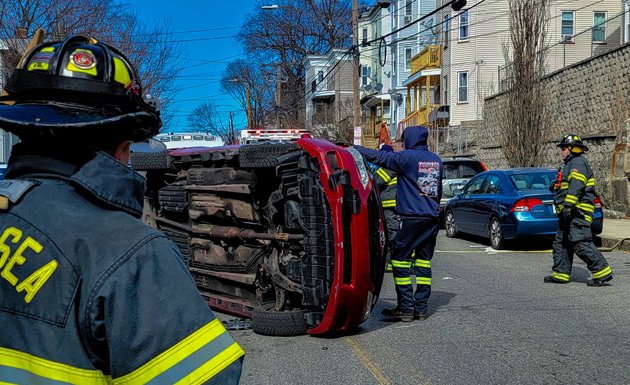 Flipped car on Washington Avenue in Chelsea with firefighters nearby