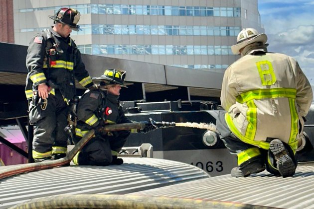 Firefighters on top of a commuter-rail train at North Station