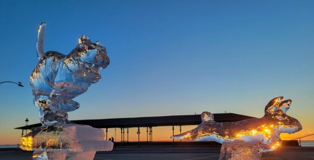 Two sculptures of racing animals at sunrise at Revere Beach