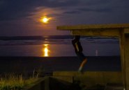 Man doing pullups under a full moon in Lynn