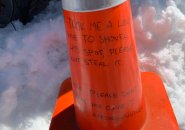 Traffic cone that urges reader not to take parking space or the cone itself in Allston