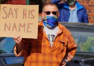 Man with sign: Say his name