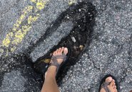 Woman up   to her ankle successful  Jamaica Plain pothole