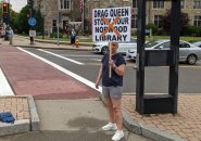 Woman holding sign against drag-queen story hour at the Norwood library