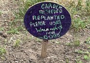 Handmade sign that asks people to stay off reseeded land at North End park