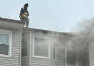 Firefighter on top of building with fire on Dorchester Avenue