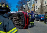 Flipped car on Washington Avenue in Chelsea with firefighters nearby