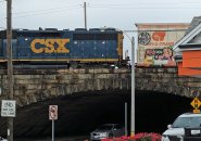 CSX locomotive pushes box cars behind Readville Dunkin' Donuts