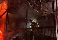 Firefighter on porch at Leston Street fire