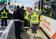 Firefighters help injured person from bus at Hyde Park Avenue and Canterbury Street