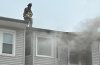 Firefighter on top of building with fire on Dorchester Avenue